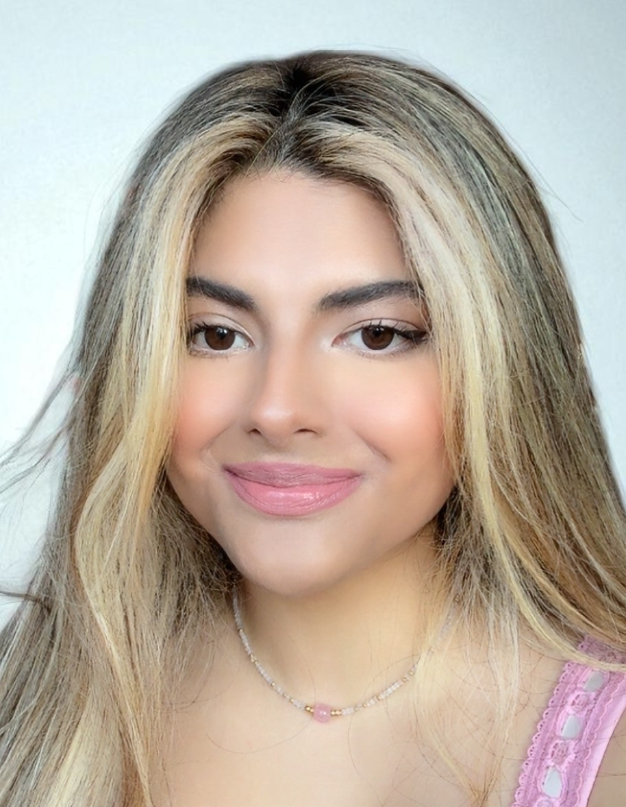 A young woman with light olive skin and blonde highlights smiling at the camera